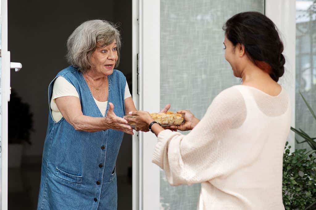 woman-offering-food-neighbor